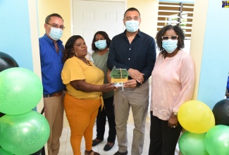 Prime Minister, the Most Hon. Andrew Holness (second right), and recipient of a three-bedroom unit under the Government New Social Housing Programme (NSHP), Clovett James (second left), display the keys to the house at a handing over ceremony, held on Friday (March 25), in Orange Bay, Portland. Others pictured from left are: Member of Parliament for Portland West, Hon. Daryl Vaz, Councillor for the Buff Bay Division, Dionne Hunter, and Permanent Secretary in the Office of the Prime Minister (OPM), Audrey Sewell.  