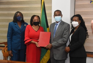 Minister of Finance and the Public Service, Dr. the Hon Nigel Clarke (second right), and Jamaica Confederation of Trade Unions (JCTU) President, Helene Davis Whyte (second left), display the signed 2021/22 Heads of Agreement for wage increases for public-sector workers represented by JCTU affiliates. Others (from left) are Financial Secretary in the Ministry, Darlene Morrison, and State Minister, Hon. Marsha Smith.