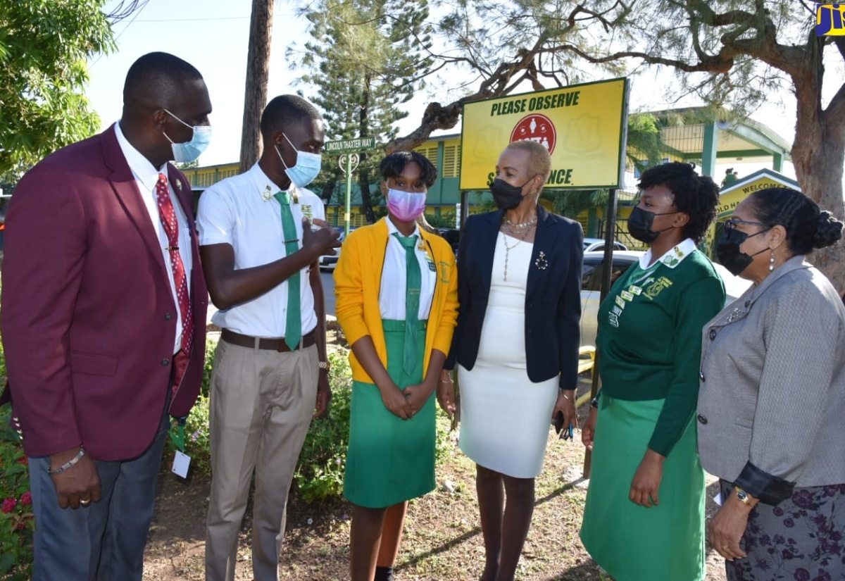 Minister of Education and Youth, Hon. Fayval Williams (third right), listens to a comment from Head Boy at the St. Catherine-based Old Harbour High School, Demario Golding (second left), while on a visit to the institution on Monday (March 7) to mark the full resumption of face-to face classes. Sharing in the conversation (from left) are Principal of the school, Lynton Weir; Vice President of the students’ council, Grena Bernard; Head Girl Claudia Mendez; and Chairman of the school board, Icylin Golding.

