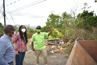 Minister of Local Government and Rural Development, Hon. Desmond McKenzie, discusses measures to address garbage pile-up along the Bellefield Hill Main Road in Manchester with Mayor of Mandeville, Councillor Donovan Mitchell, and Member of Parliament for Manchester Central, Rhoda Moy Crawford, during a tour of the constituency on Thursday (March 24). 
