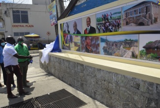 Minister of Local Government and Rural Development, Hon. Desmond McKenzie (right), and Mayor of Lucea, Councillor Sheridan Samuels, look at a mural that was unveiled at the official national launch of the ‘Paint the City, Paint the Town’ project in the Hanover capital on Friday, (April 8). 