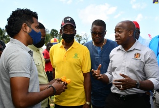Minister of Agriculture and Fisheries, Hon. Pearnel Charles Jr. (right), engages Chief Plant Breeding Officer at the Bodles Research Station in St. Catherine, Alex Sybron (left), at the 39th staging of the Montpelier Agricultural and Industrial Show in St James,  on April 18. Listening (from second left) are Acting Mayor of Montego Bay, Councillor Richard Vernon; President, Jamaica Agricultural Society’s St James chapter, Glendon Harris; and Member of Parliament, St James Central, Heroy Clarke. 