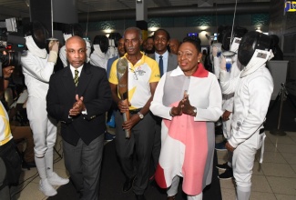 Former Jamaica track and field athlete Donald Quarrie (centre) walks with the Birmingham 2022 Queen's Baton Relay following its arrival at the Norman Manley International Airport in Kingston on April 15.  Others (from left) are President of the Jamaica Olympic Association Christopher Samuda and Minister of Culture, Gender, Entertainment and Sport, Hon. Olivia Grange. In the background is State Minister in the Ministry of Culture, Gender, Entertainment and Sport, Hon. Alando Terrelonge.