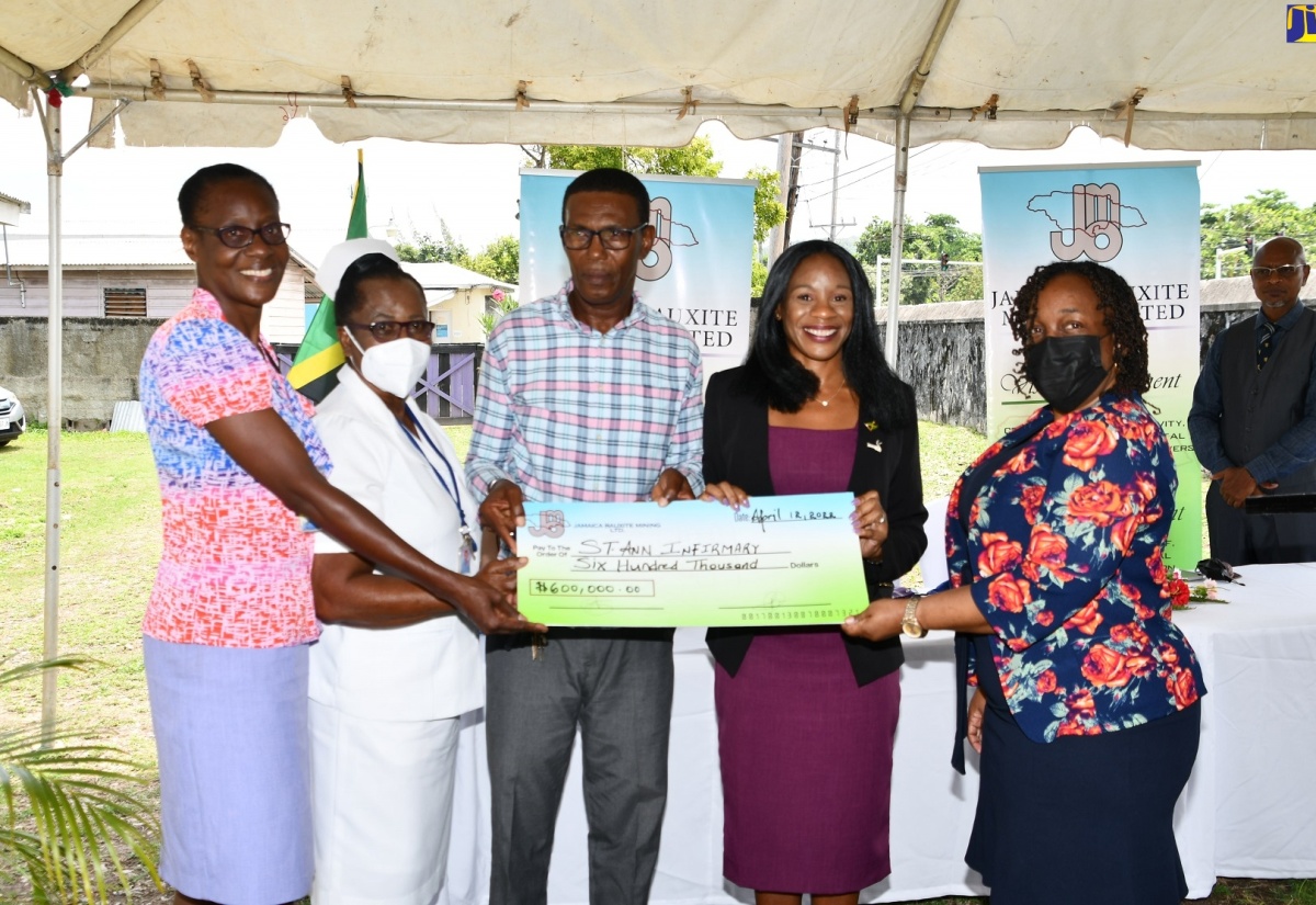 Deputy Mayor of St. Ann’s Bay and Chairman of the St. Ann Municipal Corporation’s Poor Relief Committee, Councillor Dallas Dickenson (centre) and Managing Director, Jamaica Bauxite Mining Limited (JBM), Donna-Marie Howe (second right) display a cheque valued at $600, 000, which will be used to support renovation works at the St. Ann Infirmary. The cheque, along with care packages and articles of clothing, were handed over to the Infirmary by the JMB during a ceremony held recently. Looking on (from left) are Deputy Director of the Poor Relief Department, Elaine Gabrielle; Matron at the St. Ann Infirmary, Ity Vickers and Chief Financial officer, St Ann Municipal Corporation, Ingrid Palmer.