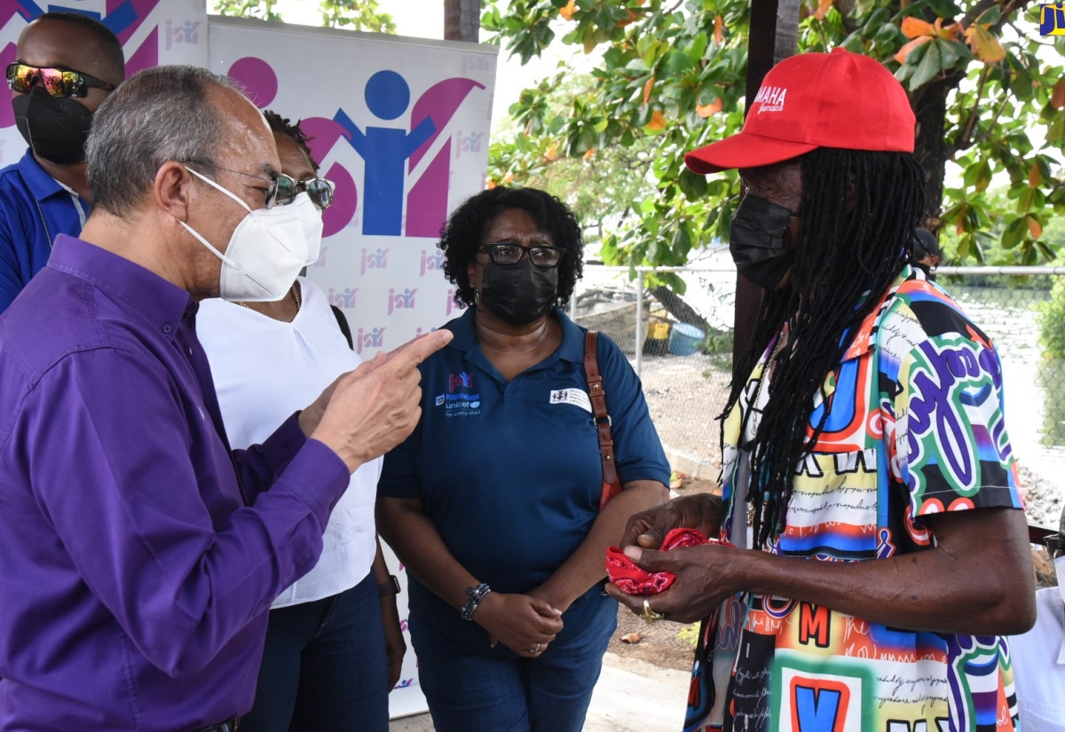 Minister of National Security and Deputy Prime Minister, Hon. Dr. Horace Chang (left), makes a point while on a recent tour of the Greenwich Town community of St. Andrew. Listening (from second left) are  Member of Parliament for St. Andrew South West, Dr. Angela Brown Burke; Senior Social Development Manager at the Jamaica Social Investment (JSIF), Mona Sue Ho, and fisherman Fitzgerald Bowers.