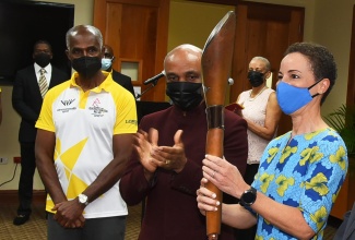 Minster of Foreign Affairs and Foreign Trade, Senator the Hon. Kamina Johnson Smith (right) holds the Queen’s Baton Relay during a presentation ceremony held at the University of the West Indies, Mona Regional Headquarters on April 16. Looking on (from left) are former track and field athlete, Donald Quarrie and President of the Jamaica Olympic Association, Christopher Samuda.