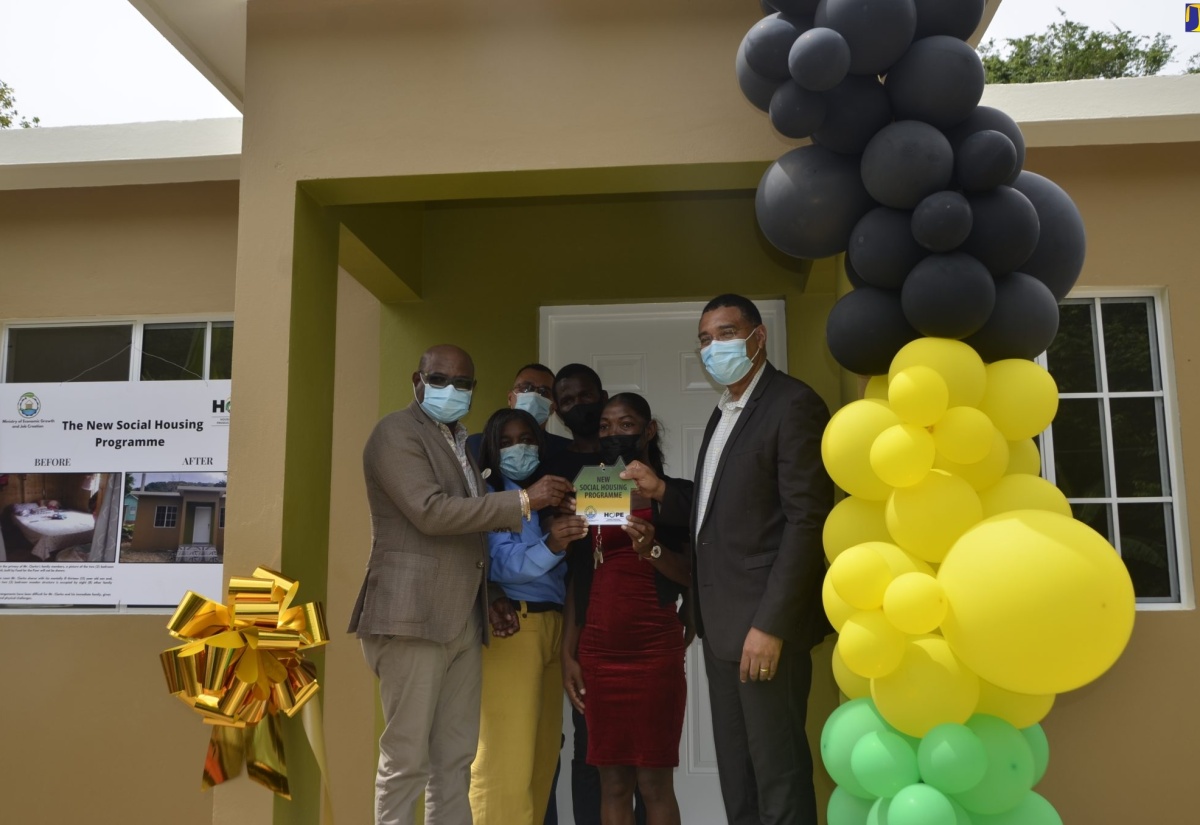 Prime Minister, the Most Hon. Andrew Holness (right), presents husband and wife, Jermaine and Jasseth Clarke (centre), with the keys to their new home in Lottery, St. James, on Friday (May 20). Joining in the occasion are Minister of Tourism Hon Edmund Bartlett (left); Chairperson of the New Social Housing Programme (NSHP), Judith Robb-Walters (second left); and Councillor of the Somerton Division, Mark McGann. 