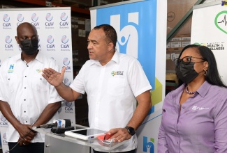 Minister of Health and Wellness, Dr. the Hon. Christopher Tufton (centre), provides details of the data centre being established to link patients’ information from all public health centres and hospitals to one central network. Joining him are (from left) the Ministry’s Information System 4 Health (IS4H), Information and Communications Technology (ICT) Lead, Shawn Bolton; and Director, Government Enterprise and Information Technology Solutions, at Cable and Wireless Communications (C&W), Carol Robertson. The Minister participated in a tour of the e-Gov Jamaica Limited Data Centre and the C&W Warehouse, which stores the equipment to be used for the project,  on May 12.

 