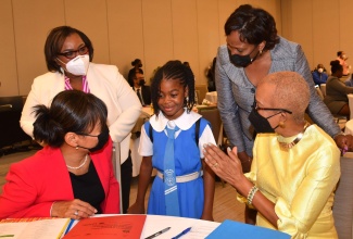 Nine year old Ngozi Wright (center) engages in conversation with (from right) Minister of Education and Youth Hon. Fayval Williams, Children’s Advocate and National Rapporteur on Trafficking in Persons Diahann Gordon Harrison, Chief Executive Officer, Child Protection and Family Services Agency, Rosalee Gage Grey and UNICEF Representative Mariko Kagoshima. Occasion was the opening ceremony for the National Policy Dialogue on Ending Violence Against Children at the AC Marriot Hotel in Kingston on Wednesday (May 25).  