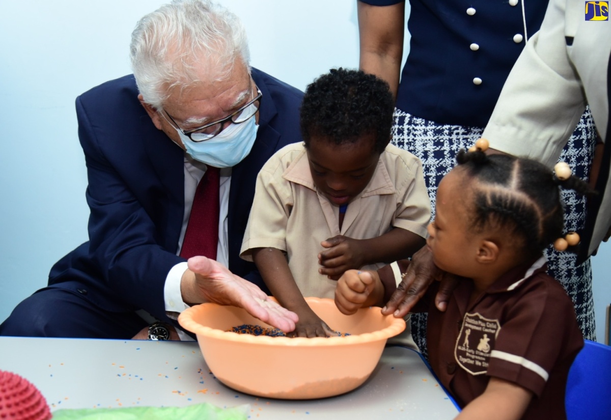 Minister of Labour and Social Security, Hon. Karl Samuda, interacts with students of the Early Stimulation Programme (ESP), Kaylee Ellis and Antoine Allen, at the opening of ESP’s sensation station, in Kingston, on May 31.