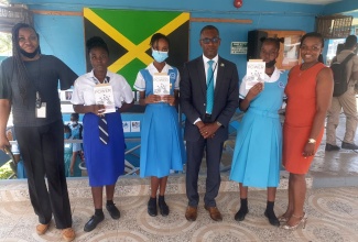 Author Simoneese Williams (right) with students at the Lacovia High School who are benefiting from the proceeds of her book, ‘Unleash Your Power’,  Anika Palmer (second left) and Stacian Brown (third left).  Others (from left) are Welfare Coordinator at Lacovia High School, Jennifer Powell; Principal of the school, Ricardo Brown; and student Jordiana Walfall.

