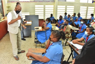 Chairman of the Jamaica Education Transformation Commission (JETC), Professor Orlando Patterson, speaks with grade-six students at May Pen Primary in Clarendon on May 30. He toured the school while engaging with stakeholders for feedback on current policies and recommendations for the education sector. 

