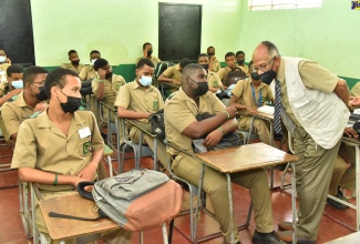 Chairman of the Jamaica Education Transformation Commission (JETC), Professor Orlando Patterson (right), engages with students of the Calabar High School, St. Andrew, during a recent visit to the institution. 