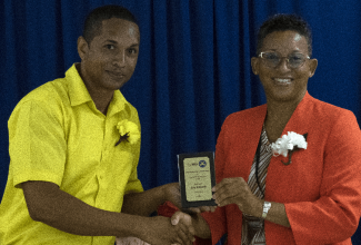 Correctional Officer Eric Edwards (left), assigned to the Rio Cobre Juvenile Correctional Centre in St. Catherine,  receives an award from Director of the Department of Correctional Services (DCS) Medical Services Unit, Dr. Donna-Michelle Royer-Powe for the most outstanding performance in the Psychiatric Nursing Aid Course, during a recent graduation exercise held at the DCS Lockett Avenue facility in Kingston.