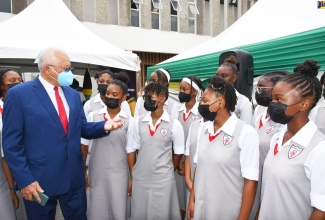 Minister of Justice, Hon. Delroy Chuck (left), engages students of The Queen’s School, during the National Public Education Day Symposium, staged at 144 Maxfield Avenue, in St. Andrew, on June 16.