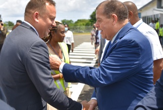 Minister of Transport and Mining, Hon. Audley Shaw (right), greets Consul General of Jamaica in Miami, Oliver Mair, at the official ceremony to welcome the arrival of the inaugural flight of Quality Corporate Aircraft Services (QCAS) Aero, out of Fort Lauderdale, at the Ian Fleming International Airport in St. Mary, on June 22. The Miami-based QCAS Aero will operate an exclusive, premium nonstop weekly flight to the airport.