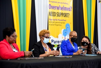 Minister of Education and Youth, Hon. Fayval Williams (second right), tries out the new mobile messaging service, ‘ParentText’ during the launch on Friday, June 17 at the Ministry’s Caenwood Auditorium, Kingston. Joining her (from left) are Chief Executive Officer, National Parenting Support Commission, Kaysia Kerr; Acting Permanent Secretary in the Ministry, Maureen Dwyer; and UNICEF International Child Protection Consultant, Ytske van Winden.

