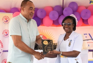 Health and Wellness Minister, Dr. the Hon. Christopher Tufton (left), presents Deputy Director,  Nursing Services (Acting),  Bellevue Hospital, Trecia Williams Morrison, with the ‘Staff Excellence Award’ in recognition of her outstanding contribution, during the institution’s Staff Wellness Day and Awards ceremony on Wednesday (July 20). The event, held at the hospital’s Windward Road address in St. Andrew, formed part of activities for National Healthcare Workers Appreciation Month.

