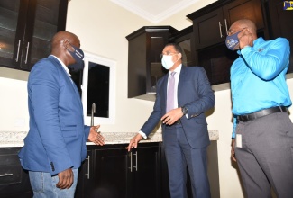 Prime Minister, the Most Hon. Andrew Holness (centre), speaks with Developer, Willard Banton (left), during a tour of a unit in the Forest Gate housing development in Red Hills, St. Andrew, on Thursday (July 7). Looking on is General Manager for the Jamaica Mortgage Bank (JMB), Courtney Wynter. 


