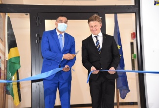 Prime Minister, the Most Hon. Andrew Holness (left), assisted by Deputy Head of the European Union (EU) Delegation to Jamaica, Fredrik Ekfeldt, cuts ribbon to open the new EU’s office at 8 Fairway Avenue in St. Andrew, on July 19.