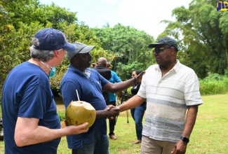 Minister of Tourism, Hon Edmund Bartlett (right) greets, Tourism Trainer/Farmer, Donovan Haughton (centre) during a visit to the Bunkers Hill Cultural Xperience and River Tours in Wakefield, Trelawny on Thursday (July 21). Looking on is Special Advisor and Former Chief Executive Officer (CEO) of the Caribbean Hotel and Tourist Association (CHTA) Frank Comito (left).  