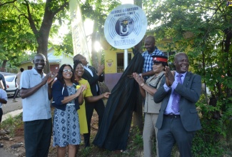 Member of Parliament for St. Elizabeth South West and Minister without Portfolio in the Office of the Prime Minister, Hon. Floyd Green (fourth from left), applauds at the unveiling of the sign for the Middle Quarters free, public wi-fi hotspot in the St. Elizabeth community on Friday, July 1. Sharing the moment are (from left): Pastor of the Middle Quarters New Testament Church of God , Rev. Arthur Grant; Councillor of the Brompton Division, Withney Smith-Currie; Principal of the Middle Quarters Primary School, Annette Kerr-Harris; Director of Projects, Universal Service Fund (USF), Kwan Wilson; Inspector Sophia Daley of the Black River Police Station; and Chief Executive Officer of the USF, Daniel Dawes.

