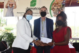 Chief Education Officer (Acting) in the Ministry of Education and Youth, Dr Kasan Troupe (left), presents Jasmine Collins (right) with a commitment letter of education assistance from Jamalco, during a ceremony at the Halse Hall Great House in Clarendon on Wednesday (July 27). Looking on is Jamalco's Managing Director, Austin Mooney.   