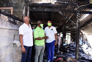 Minister of Local Government and Rural Development, Hon. Desmond McKenzie (centre), in discussion with Member of Parliament for St. Mary Central, Dr Morais Guy (left), and Mayor of Port Maria, Councillor Richard Creary, while on a tour of the fire-damaged Highgate Market in St. Mary on July 21.