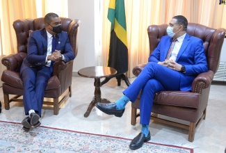 Prime Minister, the Most Hon. Andrew Holness (right), listens to a point being made by founder and Chief Executive Officer (CEO) of CGI Merchant Group, Raoul Thomas, during a courtesy call on Tuesday (July 19) at the Office of the Prime Minister.