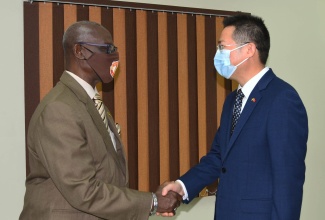 Minister of Local Government and Rural Development, Hon. Desmond McKenzie (left), greets Ambassador of the People’s Republic of China to Jamaica, His Excellency Daojiang Chen, during the diplomat’s recent courtesy call at the Ministry’s offices in Kingston.