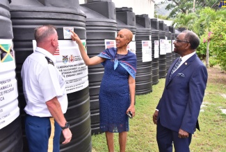 Minister of Education and Youth, Hon. Fayval Williams (centre), views one of the 100, 1000-gallon water tanks, donated by the United States (US) Southern Humanitarian Command Program (USSHCP), which will benefit 51 primary and infant schools across the island. The tanks were handed over during a ceremony held recently at Jamaica College in St. Andrew. Looking on (from left) are Senior Defense Attaché at the United Sates (US) Embassy in Kingston, Lieutenant Robert Ramsey Jr., and US Ambassador to Jamaica, His Excellency, Nick Perry.