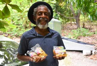 Former Rural Agricultural Development Authority (RADA) Parish Manager for St Thomas, Caswell Glover, displays some of the products manufactured by enterprise, G-Lovers Orchard in Rozelle, St Thomas.