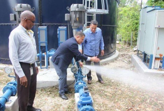 Minister without Portfolio in the Ministry of Economic Growth and Job Creation, Senator the Hon. Matthew Samuda (centre), tests the water supply system following a tour of the Flower Hill Water Supply Improvement Project in St. James on July 20. Sharing the moment are National Water Commission (NWC) Production Manager for Trelawny and St. James, Fitzgerald Roach (left) and Minister of State in the Office of the Prime Minister, Hon. Homer Davis.