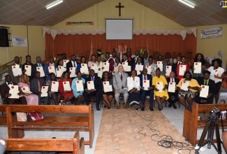 Minister of Justice, Hon. Delroy Chuck (seated, front row seventh right) and Custos of St. Thomas, Marcia Bennett (seated, front row sixth right), with the 40 newly minted Justices of the Peace in St. Thomas during a commissioning ceremony on Thursday (July 21) at the Yallahs Baptist Church in the parish.   