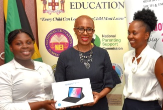 Minister of Education and Youth, Hon. Fayval Williams (centre), presents the 2021/22 Youth Policy Ambassador and winner of the National Youth Policy Creative Challenge, Samantha Blake (left), with her prize of a 4G Smart Tablet, during a recent presentation ceremony, held at the Ministry in Kingston. At right is Samantha’s Mother, Kimberly Daley. 