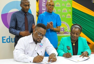 Chief Executive Officer (CEO), EduFocal Limited, Gordon Swaby (left, seated) and Director-General, Jamaica Library Service (JLS), Maureen Thompson (right, seated) sign the partnership agreement between the entities for the establishment of learning centres across the JLS network. Observing the proceedings are Education and Youth Minister, Hon. Fayval Williams (right, standing) and JLS Board Director, Dimitri South. The ceremony was held on Thursday (August 11) at the Kingston and St. Andrew Parish Library. The JLS is comprised of 111 libraries, 334 mobile library stops, and 898 school libraries across 13 parishes. 