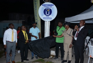 Chief Executive Officer of the Universal Service Fund, Daniel Dawes (right), is joined by (from left) Parish Manager for the St. James Health Department, Lennox Wallace; Pastor of the Redemption Chapel in Canterbury, Lascelles Thomas; Deputy Mayor of Montego Bay, Councillor Richard Vernon; St James Central Member of Parliament (MP), Heroy Clarke; and Deputy Superintendent of Police (DSP), St. James, Angela McIntosh-Gayle, in the unveiling of the sign for the Canterbury free, public Wi-Fi hotspot, in  St. James, on Monday, August 8.  