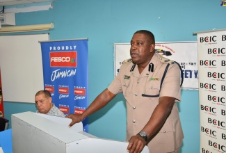 
Head of the Public Safety and Traffic Enforcement Branch (PSTEB) of the Jamaica Constabulary Force, Assistant Commissioner of Police, Gary McKenzie, addresses the recent presentation ceremony for the Blue Ribbon First Responders Training Programme at the University of Technology, Jamaica. Listening keenly is Minister of Transport and Mining, Hon. Audley Shaw.  

