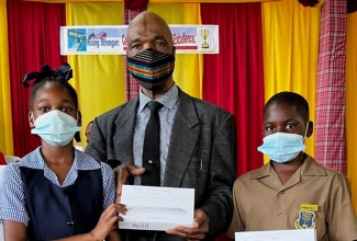 Retired educator, Melvin McDonald (centre), presents a tablet to Dinthill Technical High School student, Ebony Richard (left), while her schoolmate, Doje Bailey, shows off his device. The New York-based Jamaican visited the institution in St. Catherine recently, where he handed over a portion of the 586 tablets that he has donated to benefit students from the parish and St. Mary.