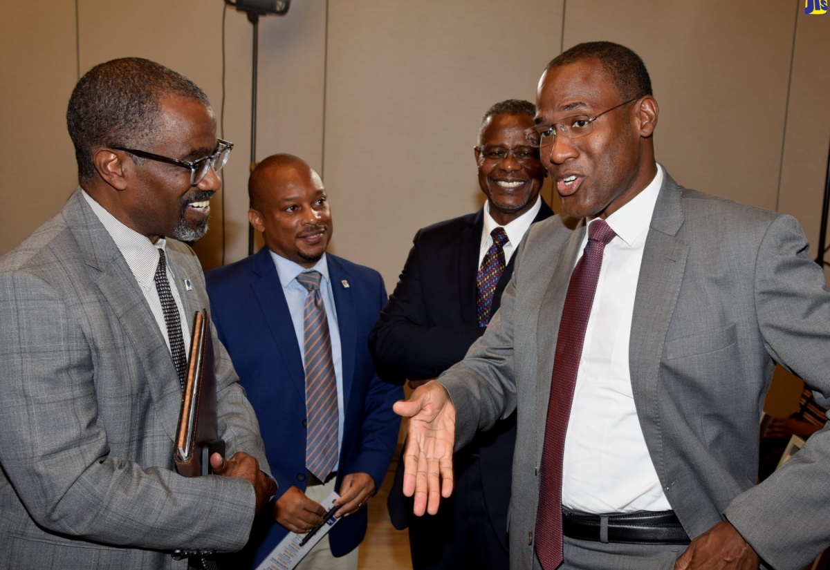 Minister of Finance and the Public Service, Dr. the Hon. Nigel Clarke (right), converses with Development Bank of Jamaica (DBJ) Managing Director, Anthony Shaw (left), during Thursday’s (August 11) launch of the entity’s Entertainment and Transport Sector Loan products, at the AC Marriott Kingston Hotel. Sharing in the discussion are General Manager for DBJ’s Channels, Relationship and Marketing Division, Edison Galbraith (second left); and DBJ Manager for Investor Relations, Paul Chin.   