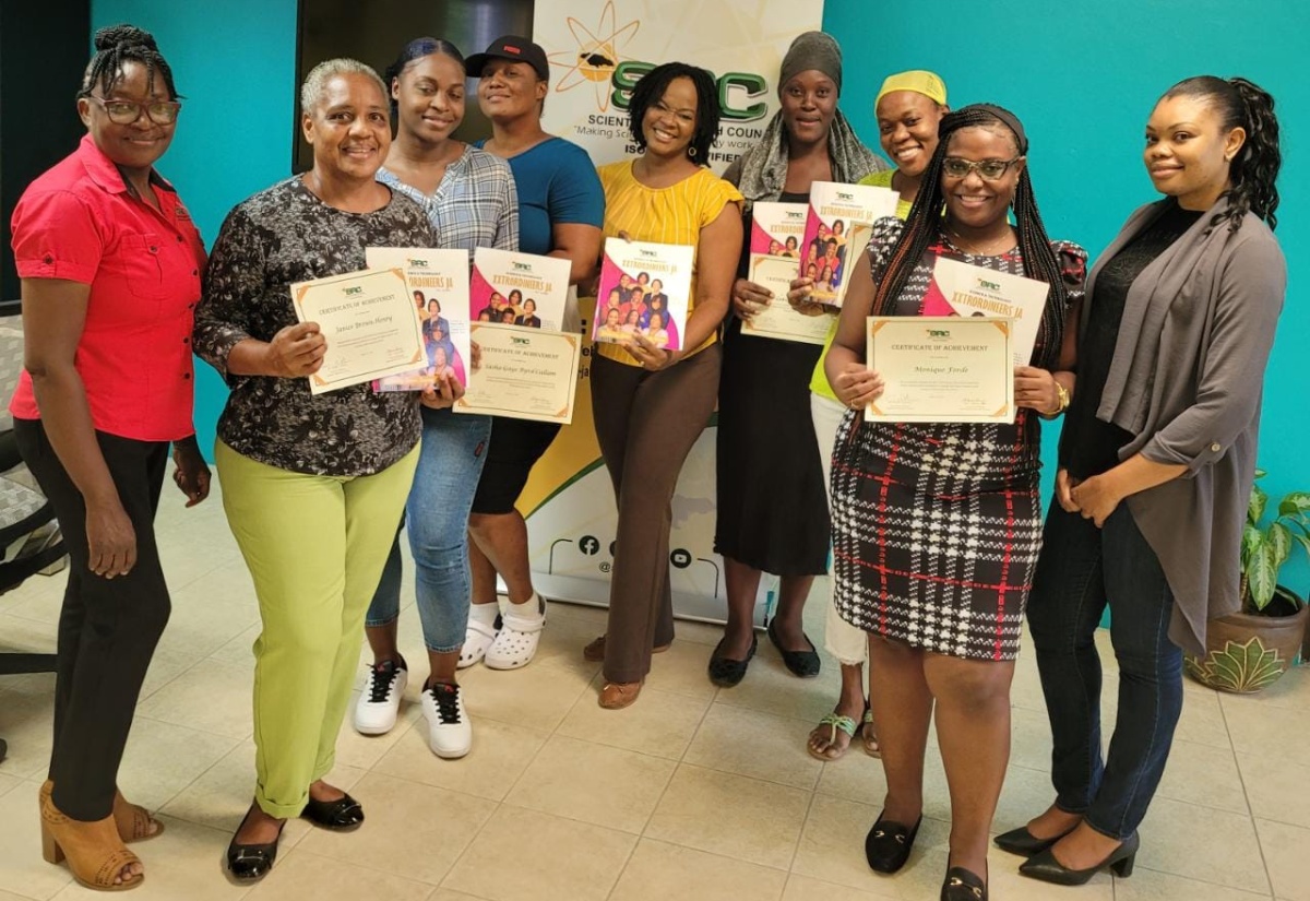 Executive Director of the Scientific Research Council, Dr. Charah Watson (centre) and Coordinator for the Science and Technology Education Unit at the Council, Kavelle Hylton (right), share a moment with some of the participants of the summer attachment programme.