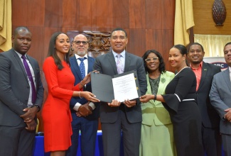 Prime Minister the Most Hon. Andrew Holness (fourth left), and Managing Director, Arc Properties Limited, Ashley-Ann Horne (second left), display the Memorandum of Understanding (MoU) signed on Tuesday (August 23) between the Ministry of Economic Growth and Job Creation and Arc Properties Limited, for the contribution of units to the New Social Housing Programme. Others (from left) are: Managing Director, Kinetic Engineering Services, Keon Hinds; President, Private Sector Organisation of Jamaica, Keith Duncan; Permanent Secretary in both the Office of the Prime Minister and the Ministry of Economic Growth and Job Creation, Audrey Sewell; Director of Arc Properties and Deputy Chair of Arc Manufacturing, Charlotte Horne Hayles; Minister without Portfolio in the Office of the Prime Minister, Hon. Floyd Green, and Minister without Portfolio in the Ministry of Economic Growth and Job Creation, Senator the Hon. Matthew Samuda.

