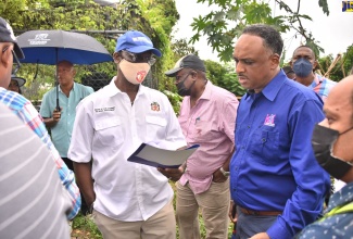 Minister of Local Government and Rural Development, Hon. Desmond McKenzie (left), makes a point to Managing Director, Jamaica Social Investment Fund (JSIF), Omar Sweeney, during a tour of Cheswick, St Thomas, on August 30. The community is next to benefit from the Rural Development Programme, spearheaded by the Ministry.