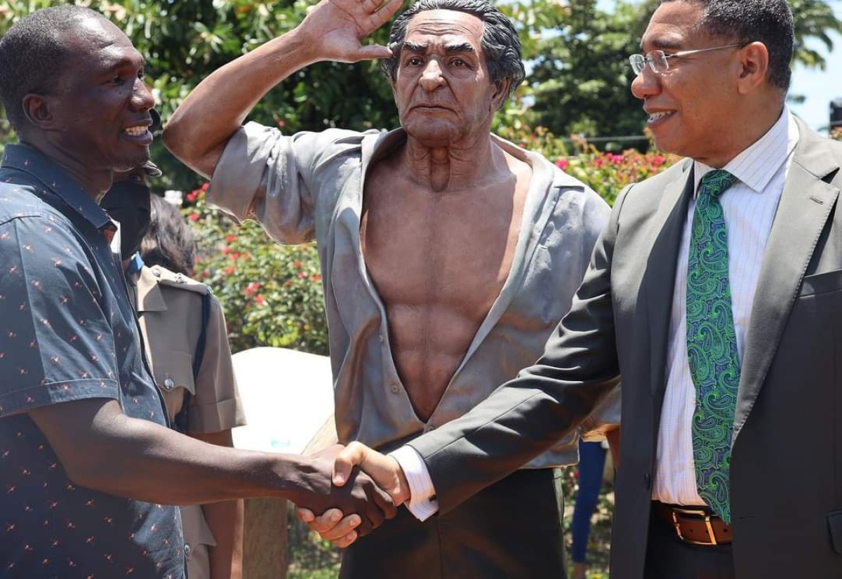 Prime Minister, the Most Hon Andrew Holness (right) greets Sculptor Sched Cole (left), following the unveiling of the statue of the Rt Excellent Sir Alexander Bustamante at the Hanover Parish Library, Lucea on Friday (August 12). 