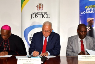 Justice Minister, Hon. Delroy Chuck (centre); Chairman, Jamaica Umbrella Groups of Churches and Roman Catholic Archbishop of Kingston, His Grace Most Rev. Kenneth Richards (left), and Vice President, the Independent Churches of Jamaica, Bishop Dr. Michael Smith, sign a memorandum of understanding (MOU) between the State and the churches for a restorative justice programme. The ceremony took place at the Ministry’s office in Kingston on September 6.