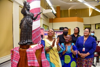 Culture, Gender, Entertainment and Sports Minister, Hon. Olivia Grange (left, front row), applauds following the unveiling of a statuette depicting late cultural icon, Dr. the Hon. Louise “Miss Lou” Bennett-Coverley, during a ceremony at the University of the West Indies (UWI), Mona, Library in St. Andrew, on Wednesday (September 7). The unveiling formed part of the opening of the Miss Lou Exhibition, which is among several activities commemorating the 103rd anniversary of the beloved cultural exponent’s birth. With Minister Grange are Director of the Institute for Gender and Development Studies Regional Coordinating Office, UWI,  Professor Opal Palmer Adisa, (right, front row) and (from left, back row) Coordinator, Jamaican Language Unit, Dr. Joseph Farquharson; Head Department of Language, Linguistics and Philosophy, Dr. Vivette Milson-Whyte; Acting Executive Director, Jamaica Cultural Development Commission (JCDC), Marjorie Leyden Kirton; and Acting UWI Campus Librarian, Jessica Lewis Marshall. 