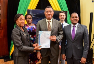 Prime Minister, the Most Hon. Andrew Holness (centre), hands over a birth certificate to Tavia Richards-Murray,  Guardian for Ashley Williams, one of the first recipients under the National Identification System’s (NIDS) ‘Operation Birthright’ Project, that was launched at Jamaica House in Kingston, on Friday (September 9). Sharing the moment are: Minister without Portfolio in the Office of the Prime Minister, Hon. Floyd Green (right); Modernisation of State Specialist, Inter-American Development Bank, Benjamin Roseth (second right); and Representative of the Leader of the Opposition, Dr. Angela Brown-Burke.

