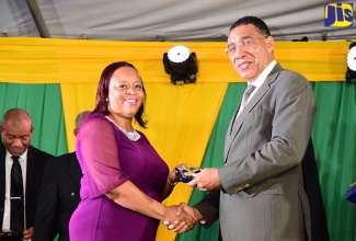 Prime Minister, the Most Hon. Andrew Holness (r) presents Principal of the Mt. Zion Primary and Infant School in St. James, Onex Bowen, with the Prime Minister’s Medal of Appreciation for Service to Education, during a ceremony held on September 8 at Jamaica House.

