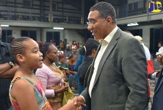 Prime Minister, the Most Hon. Andrew Holness, greets grade five student at New Life Preparatory, Cataleya Elliott, during a recent education townhall meeting at Jamaica College in St. Andrew.