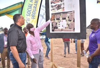 Prime Minister, the Most Hon. Andrew Holness (left), is shown aspects of the plans for the $71-million Victoria Palms housing development in Denham Town, Kingston Western, Minister of Local Government and Rural Development and Member of Parliament, Hon. Desmond McKenzie (second left), following the ground-breaking ceremony on Friday (September 2). Looking on is City Engineer for the Kingston and St. Andrew Municipal Corporation (KSAMC), Zavia Chevannes. The project is being executed under the New Social Housing Programme (NSHP).